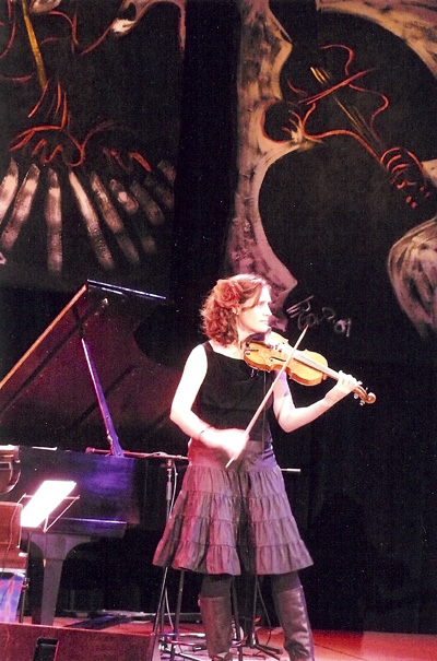 Violinist Jenny Scheinman plays in front of E.J. Gold's JazzArt